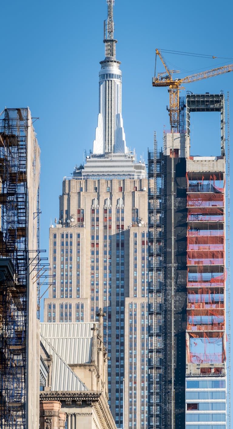 Empire State Building amidst construction in NYC, showcasing urban transformation.